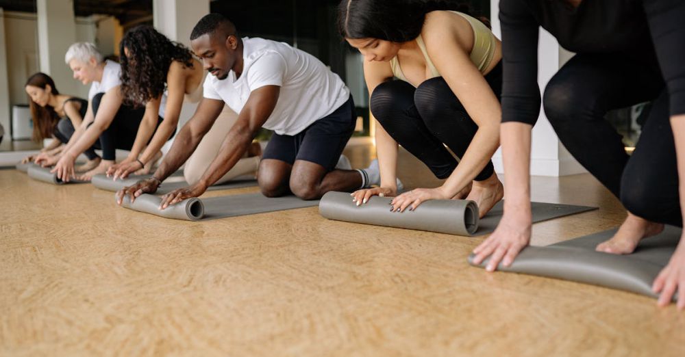 Rolling Mats - Adults rolling yoga mats in a studio after a calming group exercise session.