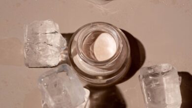 Ice Cream Products - Flat lay of a skincare product surrounded by ice cubes on a textured surface.