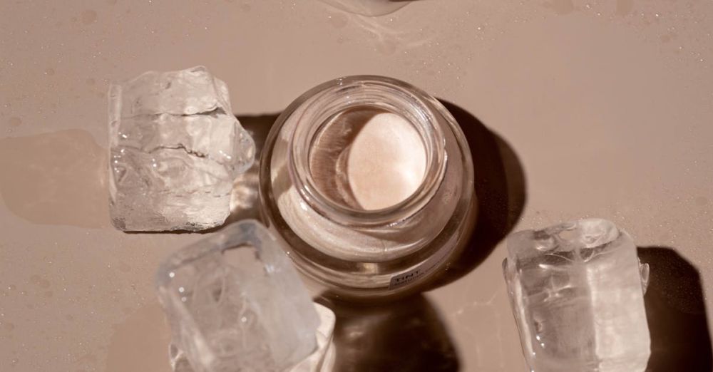 Ice Cream Products - Flat lay of a skincare product surrounded by ice cubes on a textured surface.