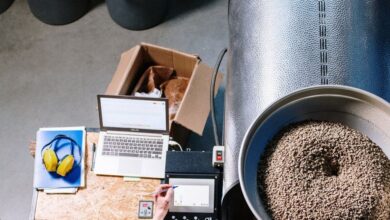 Storage Bins - An overhead view of a man operating a coffee roaster in an industrial setting.