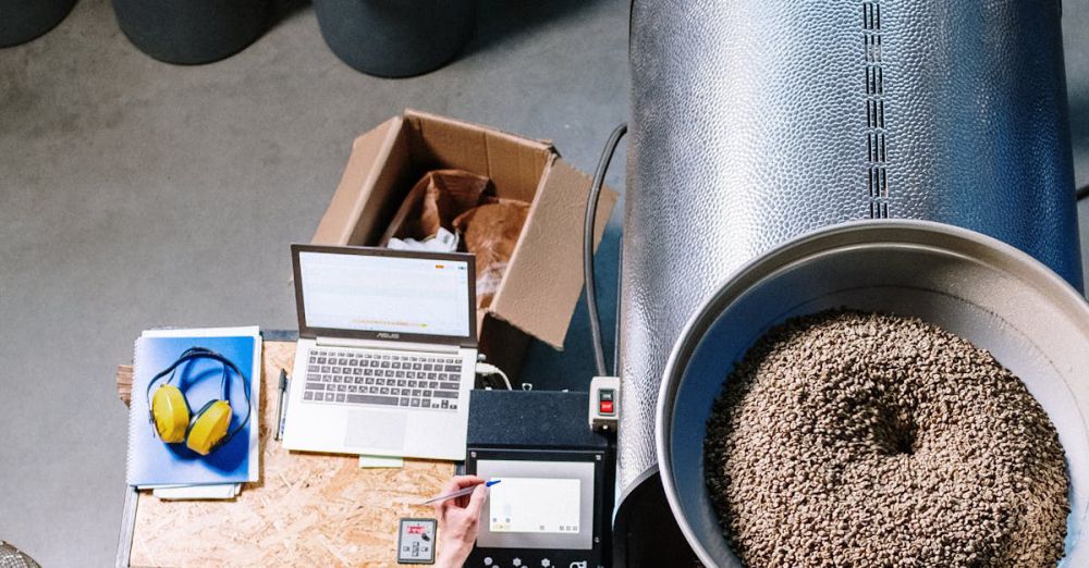 Storage Bins - An overhead view of a man operating a coffee roaster in an industrial setting.