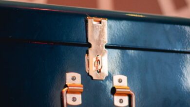 Luggage Locks - A close-up view of a shiny metallic lock on a blue suitcase indoors.