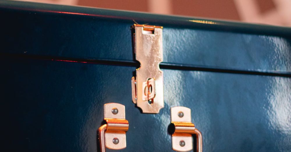 Luggage Locks - A close-up view of a shiny metallic lock on a blue suitcase indoors.