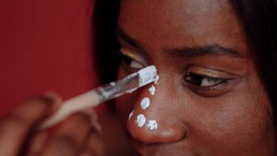 Shoe Organizers - A close-up portrait of a woman getting traditional face paint applied during a studio shoot.