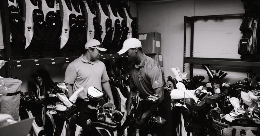 Garment Bags - Two men sorting and organizing golf bags and clubs in a storage room.