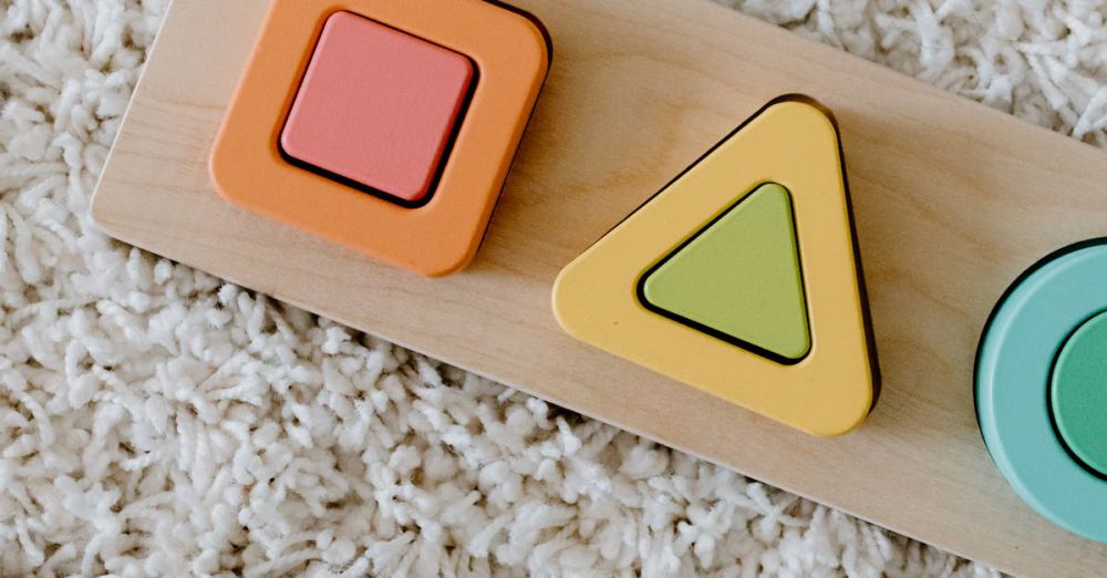 Learning Toys - Close-up of colorful wooden educational toys on a textured carpet.