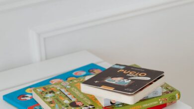 Picture Books - Vertical shot of children's books stacked on a white table in a bright space.