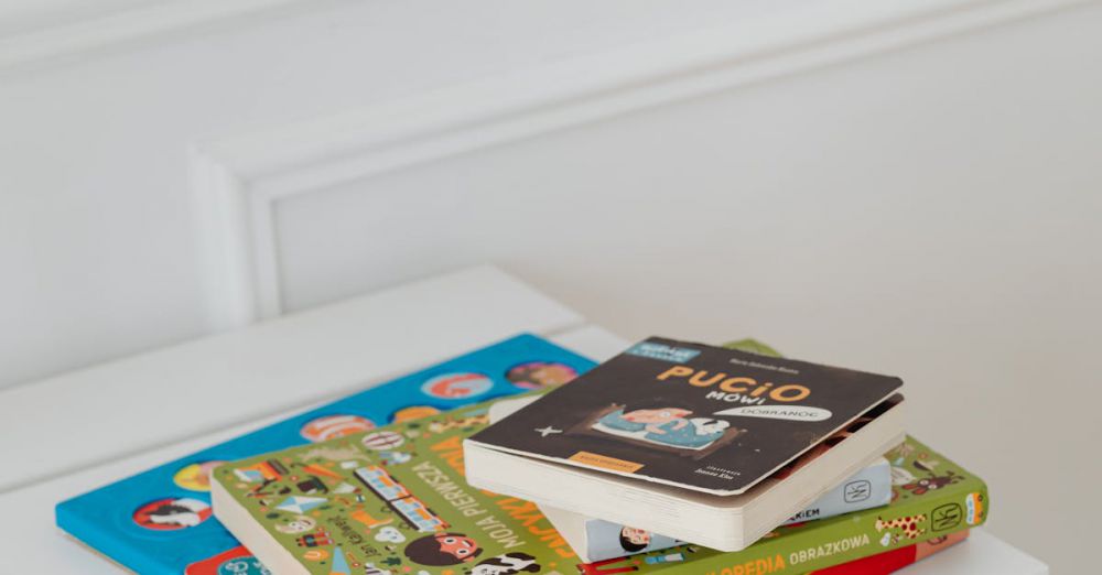 Picture Books - Vertical shot of children's books stacked on a white table in a bright space.