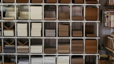 Reading Products - Neat stacks of various books and papers arranged on white shelving units.