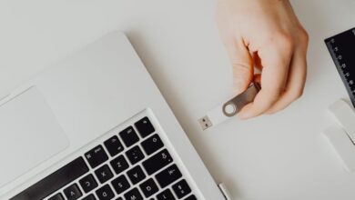 Flash Drives - Hand inserting USB drive into laptop. Modern tech connection concept.