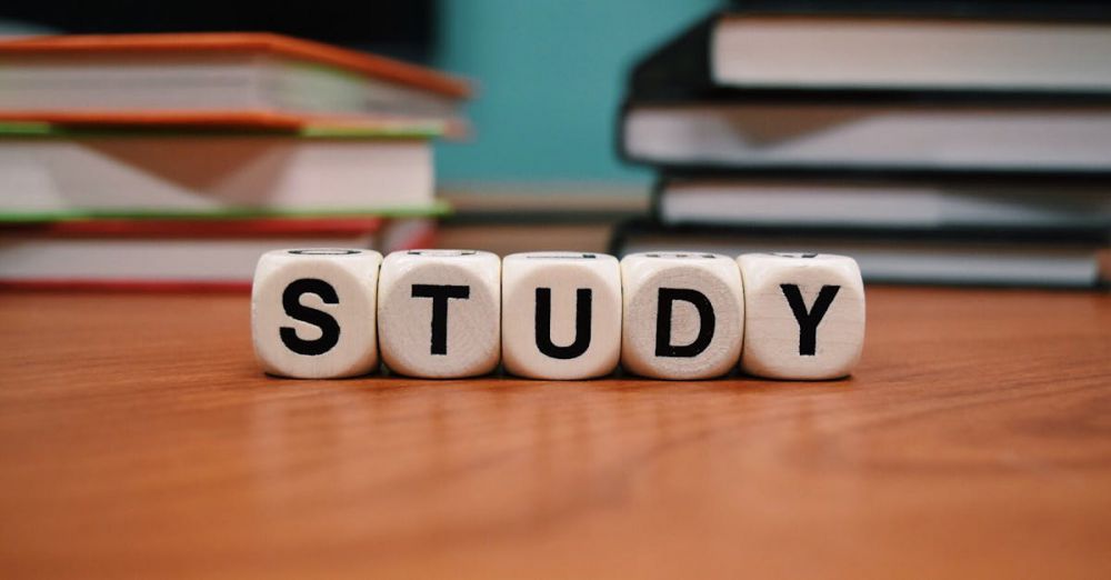 Learning Tools - Close-up of study blocks and stacked books on a wooden desk, symbolizing education and learning.