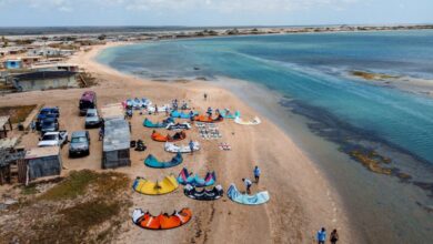 Activity Kits - A vibrant aerial view of kitesurfers setting up on Santa Rita Beach, Venezuela.