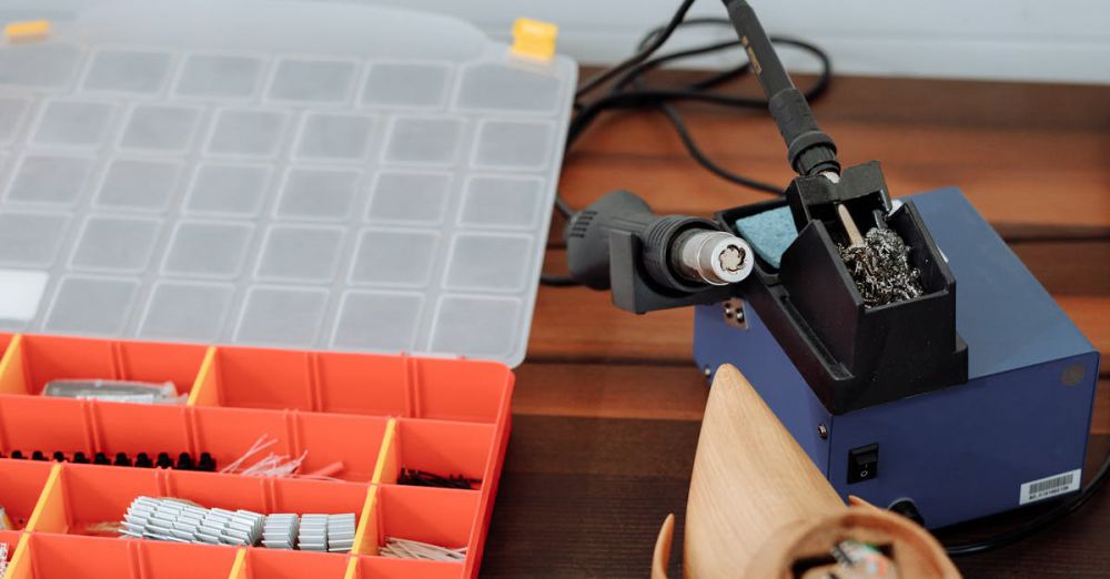 Kits - A soldering station with tools and components on a wooden table for electronics work.