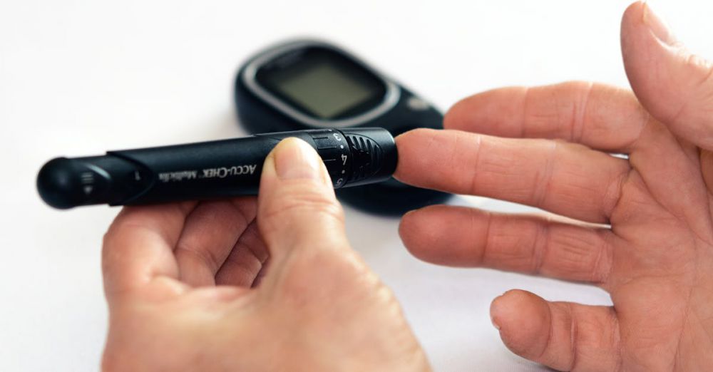 Reading Kits - Close-up image of a person using a glucometer for diabetes management indoors.