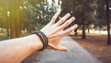 Bracelets - A hand with bracelets reaching out in a sunlit forest path, Vilnius.