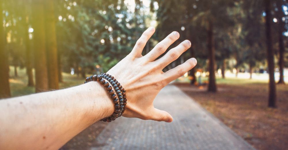 Bracelets - A hand with bracelets reaching out in a sunlit forest path, Vilnius.