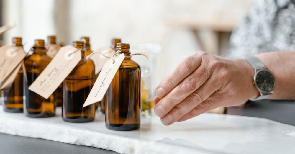 Watch Products - Close-up of essential oil bottles with handwritten labels and a hand reaching for one.