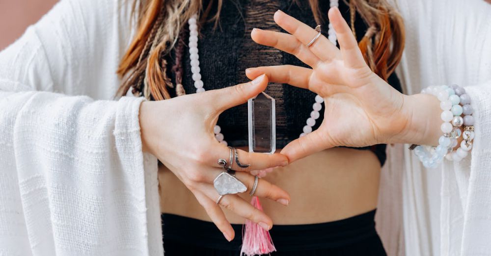 Charm Bracelets - A woman wearing jewelry holds a clear healing crystal, symbolizing spiritual wellness.