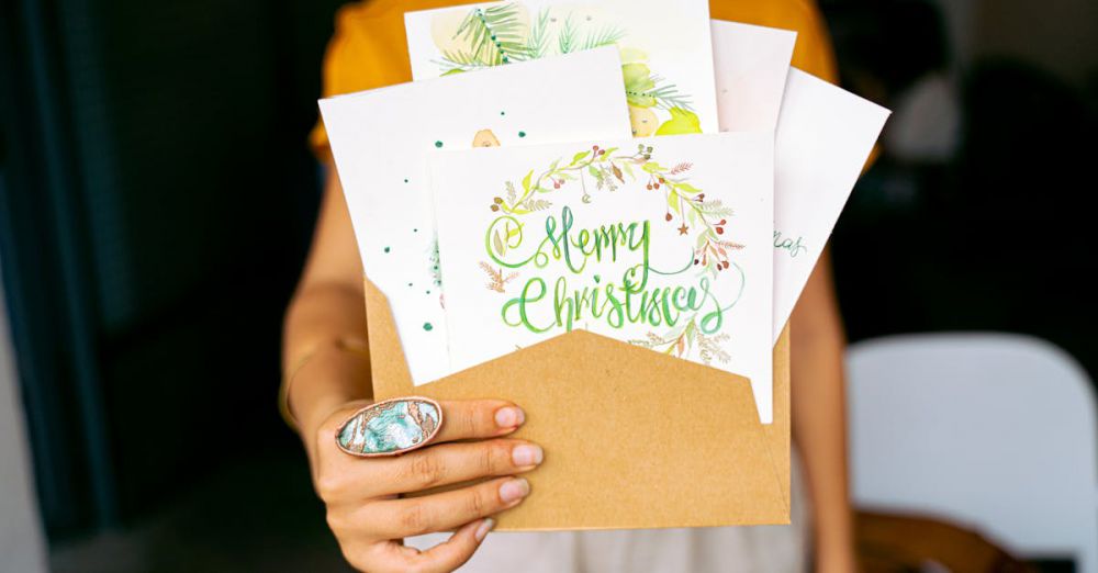 Customized Jewelry - A close-up view of hands holding decorative Christmas cards in an envelope.