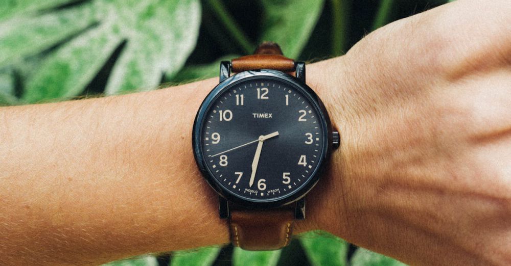 Outdoor Watches - Man's wrist wearing a stylish watch in front of lush green foliage showcasing nature.