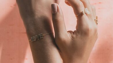 Jewelry Trends - Close-up of hands adorned with delicate rings and bracelets against a soft background.